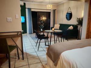 a hotel room with a bed and a table and chairs at The Neighborhood Haven in Richards Bay