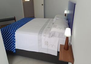 a bed with a blue and white blanket and a lamp at Yaque Breeze - Beach Apartament in El Yaque +41 photos