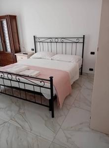 a bedroom with a large bed with a pink blanket at Valentina GuestHouse in Sestu