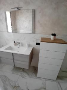 a white bathroom with a sink and a mirror at Valentina GuestHouse in Sestu