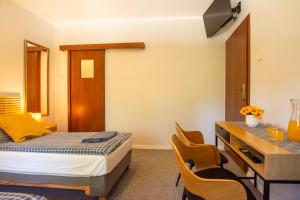 a bedroom with a bed and a desk and chairs at Dom na Folwarku POKOJE I APARTAMENTY, BEZPŁATNY ZAMYKANY PARKING NA TERENIE POSESJI in Kielce