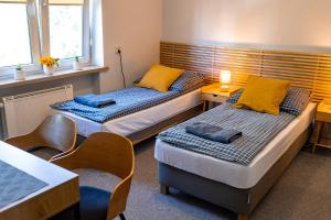 a room with two beds and a table and chairs at Dom na Folwarku POKOJE I APARTAMENTY, BEZPŁATNY ZAMYKANY PARKING NA TERENIE POSESJI in Kielce