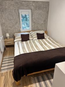 a large bed in a bedroom with a window at Arborétum in Harkány