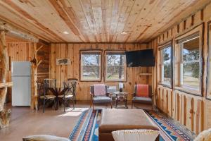a living room with wooden walls and a table and chairs at Sun Filled Joy BHBungalows #8 in Custer