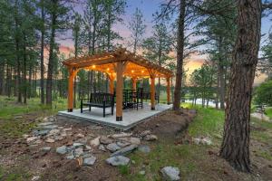 a gazebo with tables and benches in the woods at Sun Filled Joy BHBungalows #8 in Custer