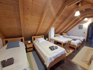 a room with three beds and a table in it at Limbus Fogadó in Gyöngyöstarján