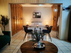 a living room with a table and a bed at The Neighborhood Haven in Richards Bay