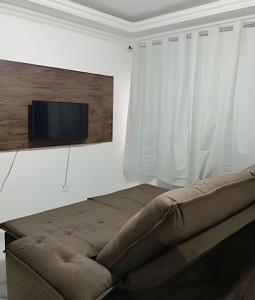 a living room with a couch and a flat screen tv at Apartamento próximo a Lagoa do Perola in Governador Valadares