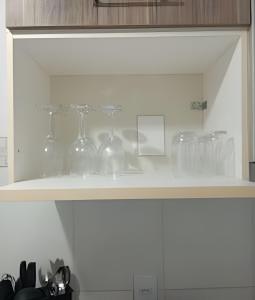 a shelf filled with glassware on top of a kitchen counter at Apartamento próximo a Lagoa do Perola in Governador Valadares +11 photos