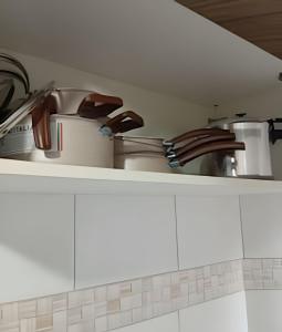 a kitchen counter with a sink and pots and pans at Apartamento próximo a Lagoa do Perola in Governador Valadares