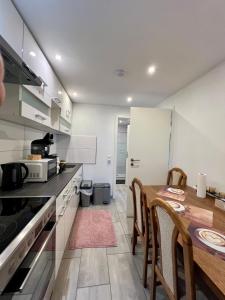 a kitchen with a table and chairs and a kitchen with white cabinets at Apartment Marin in Bad Wildbad