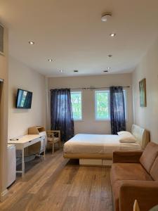 a bedroom with a bed and a couch at Dragon Gate Inn in Toronto