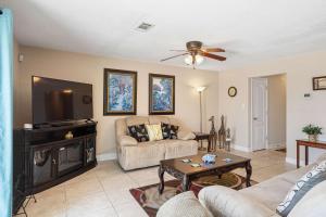 a living room with a couch and a flat screen tv at Waterfront Views & Beach Access - pet friendly in Navarre