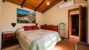 a bedroom with a bed and a painting on the wall at Casa Nazari in Benaocaz +17 photos
