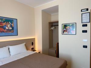 a bedroom with a bed and some pictures on the wall at Hotel Molise 2 in Milan