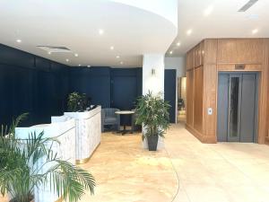 an office lobby with potted plants and a counter at voco London - Bloomsbury by IHG in London