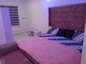 a bedroom with a large bed with a red headboard at Four bedroom duplex in Lagos