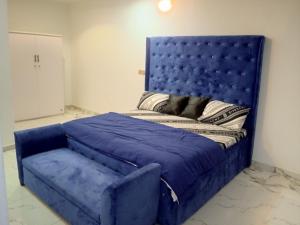 a blue bed with a dog laying on top of it at Four bedroom duplex in Lagos