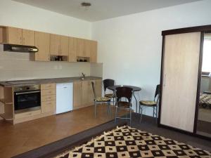 a kitchen with wooden cabinets and a table and chairs at Penzion Lipina in Slatiňany