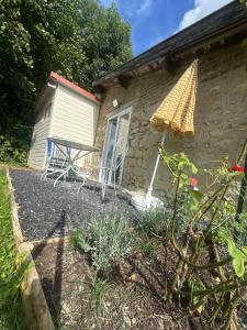 a house with a table and a picnic table outside at L Empreinte in Saint-Juvin