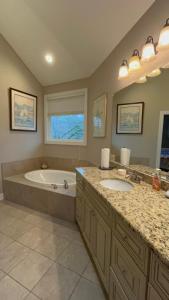 a bathroom with two sinks and a bath tub at Spacious Lakefront in Fayetteville +10 photos
