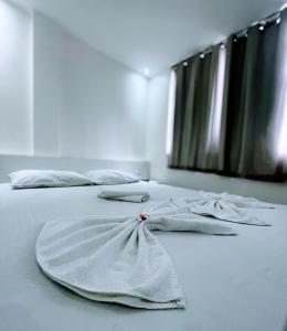 a white bed with a dress on top of it at Princesa do Sertão Pousada in Palmeira dos Índios +16 photos