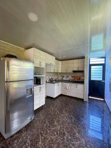 a large kitchen with a stainless steel refrigerator at Valso Posada Campestre in Silvania
