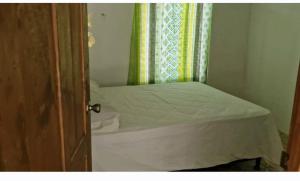 a small bedroom with a bed and a window at Chemas alojamiento in Pochote