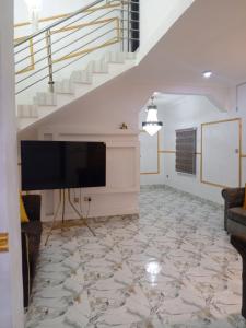 a living room with a flat screen tv and a staircase at Four bedroom duplex in Lagos