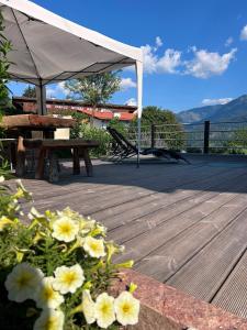a wooden deck with a picnic table and an umbrella at Appartamento Graziella in Castello di Fiemme