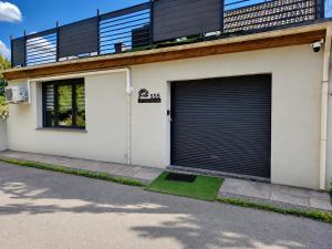 a white house with two garage doors on it at La Villa d'Elioth in Vred