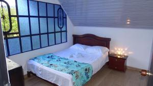 a bedroom with a bed with a blue and white comforter at Valso Posada Campestre in Silvania