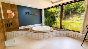 a bathroom with a sink and a large window at Pousada Valle dos Pássaros in Penedo