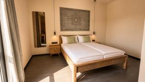a bedroom with a bed and a mirror at D&C Hotel Sulingen in Sulingen