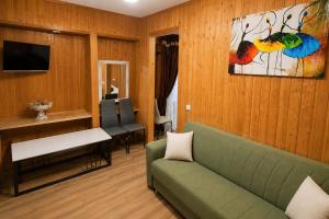a living room with a green couch and a table at Guest House Leon in Batumi