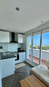 a kitchen with white cabinets and a large window at Chez Lima in Lorient