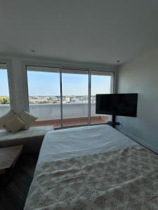 a bedroom with a bed and a flat screen tv at Chez Lima in Lorient