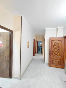 a hallway with a wooden door and white walls at Cairo gust house in Alexandria