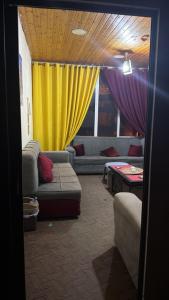 a living room with couches and a yellow curtain at Cairo gust house in Alexandria