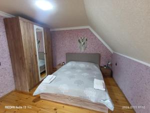 a bedroom with a bed with a pink wall at Sheki Dream House in Sheki