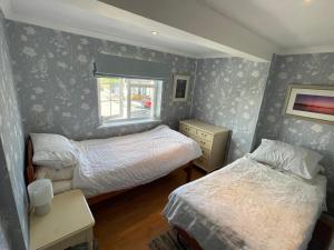 a small bedroom with two beds and a window at The Coach House in Braunton