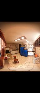 a large kitchen with blue cabinets and a table at Casa Maravilha in Aquiraz