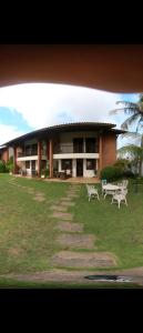a building with two white benches in front of it at Casa Maravilha in Aquiraz