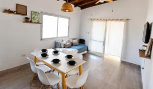 a living room with a table and chairs and a couch at Casa de los Cerros I - Vaqueros in Vaqueros