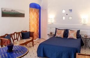 a bedroom with a blue bed and a couch at La Estrella de Tarifa in Tarifa