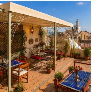 an outdoor patio with tables and chairs and a pavilion at Riad Fes Layan in Fez