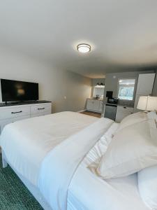 a bedroom with a large white bed and a flat screen tv at Meadow Room at The Trailblazer Unit 12 in Townsend