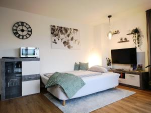 a white bedroom with a bed and a tv at Kapellenblick Auszeit mit Ausblick in Heroldstatt