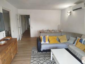 a living room with a gray couch and yellow pillows at Imperial Tarraco Apartment in Tarragona