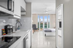 a kitchen with a sink and a bedroom with a bed at Premier Ocean Lagoon Studio · Condado with Pool in San Juan